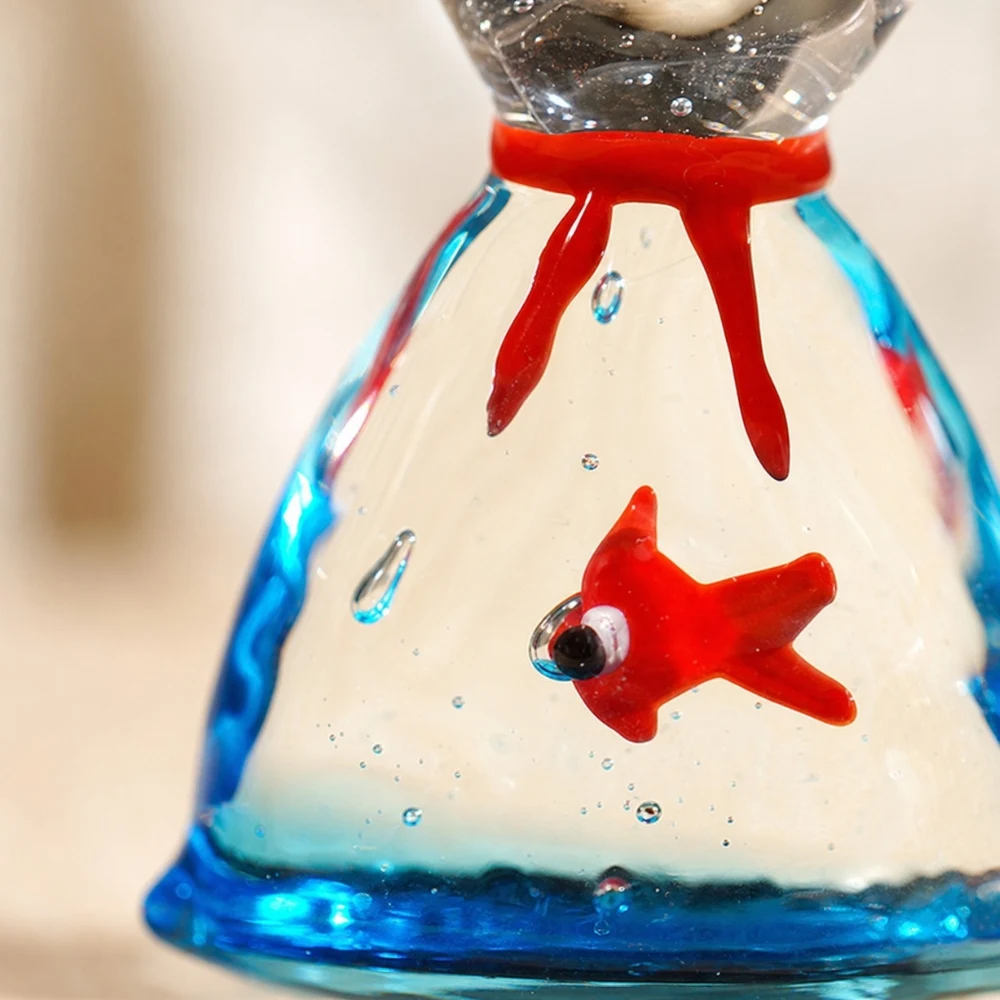 Detailopname van een handgemaakt glazen visornament in rood en blauw.