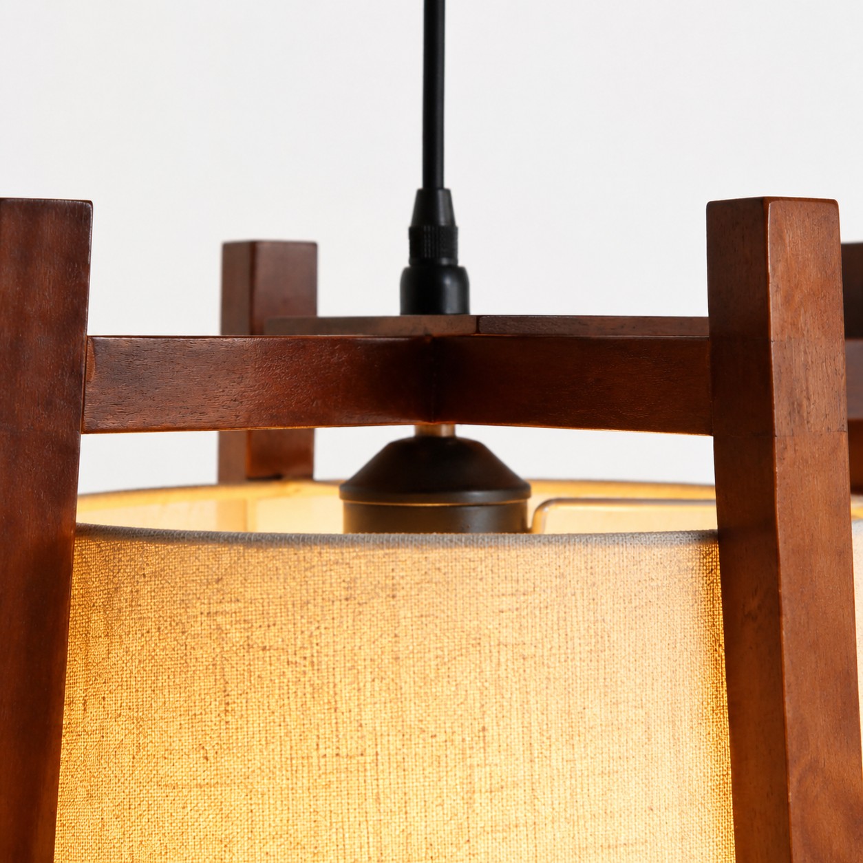 Close-up of walnut finish top frame and black cord