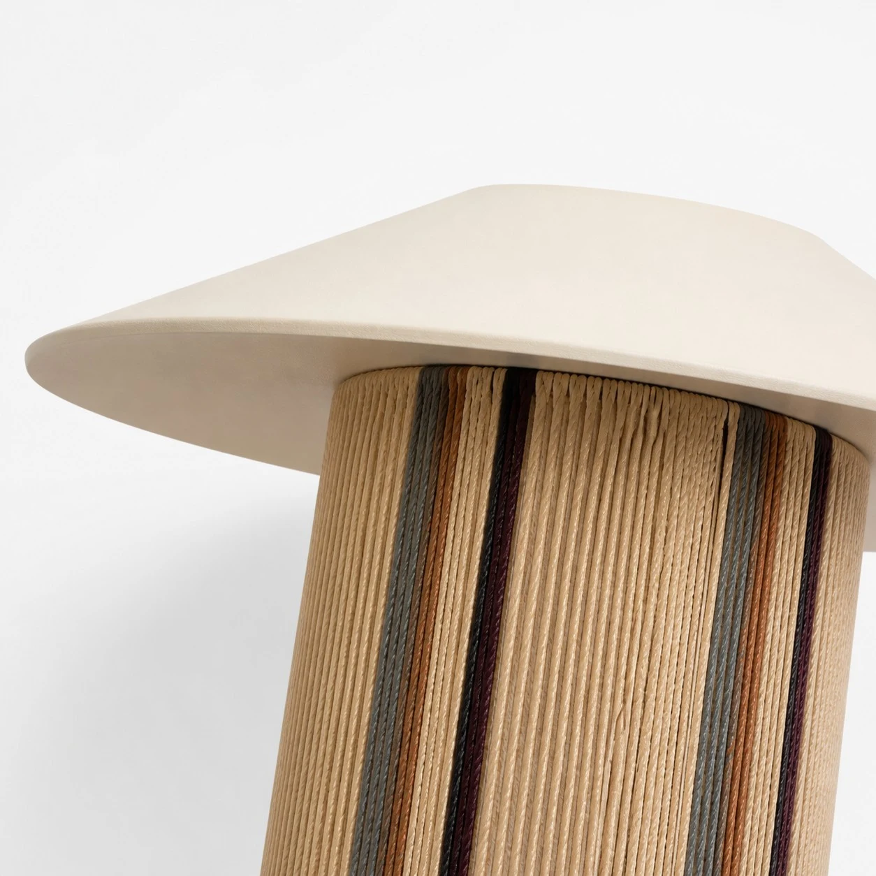 Paralume plissettato in tessuto intrecciato per applique da parete e dettaglio del cappuccio angolato.