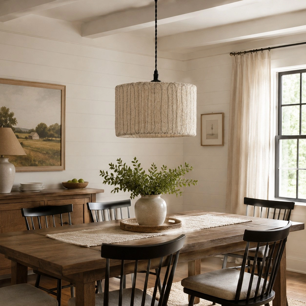 Hanglamp van natuurlijk loofahhout boven een houten eettafel.