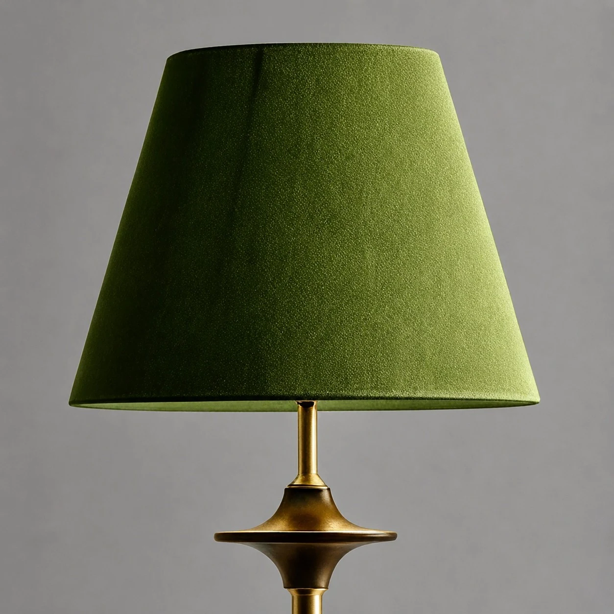 Paralume in tessuto verde e stelo della lampada color ottone.
