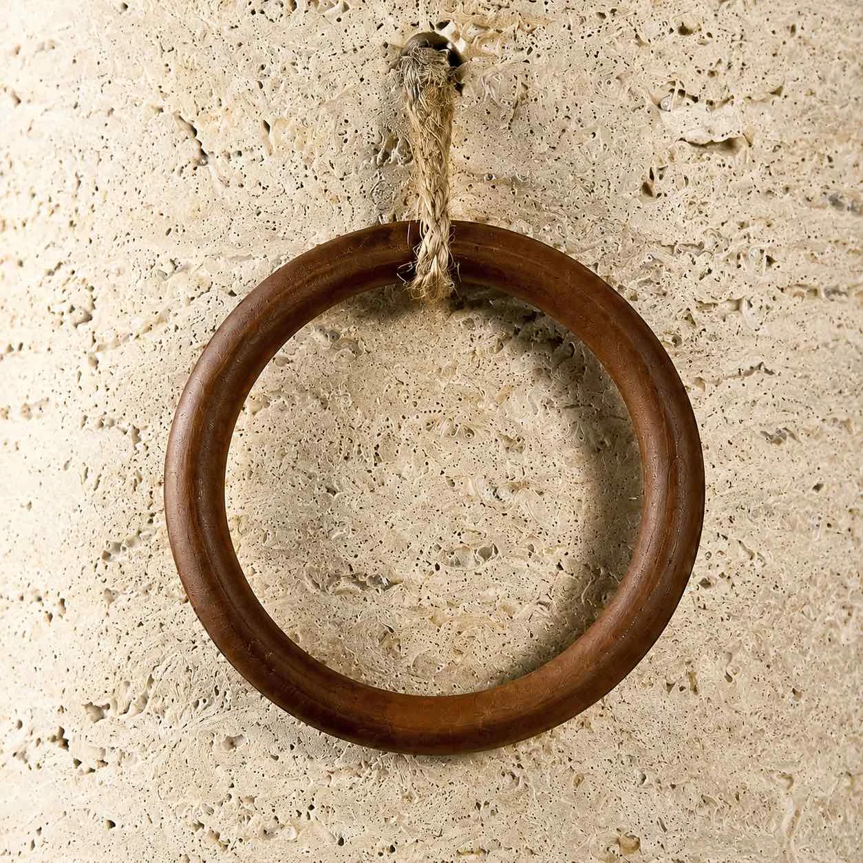Dettaglio dell'anello in legno e del cavo di sospensione sulla lampada da parete.