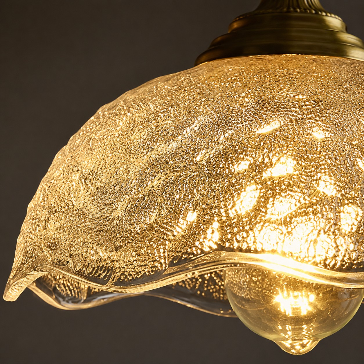 Paralume in vetro pressato trasparente illuminato da vicino