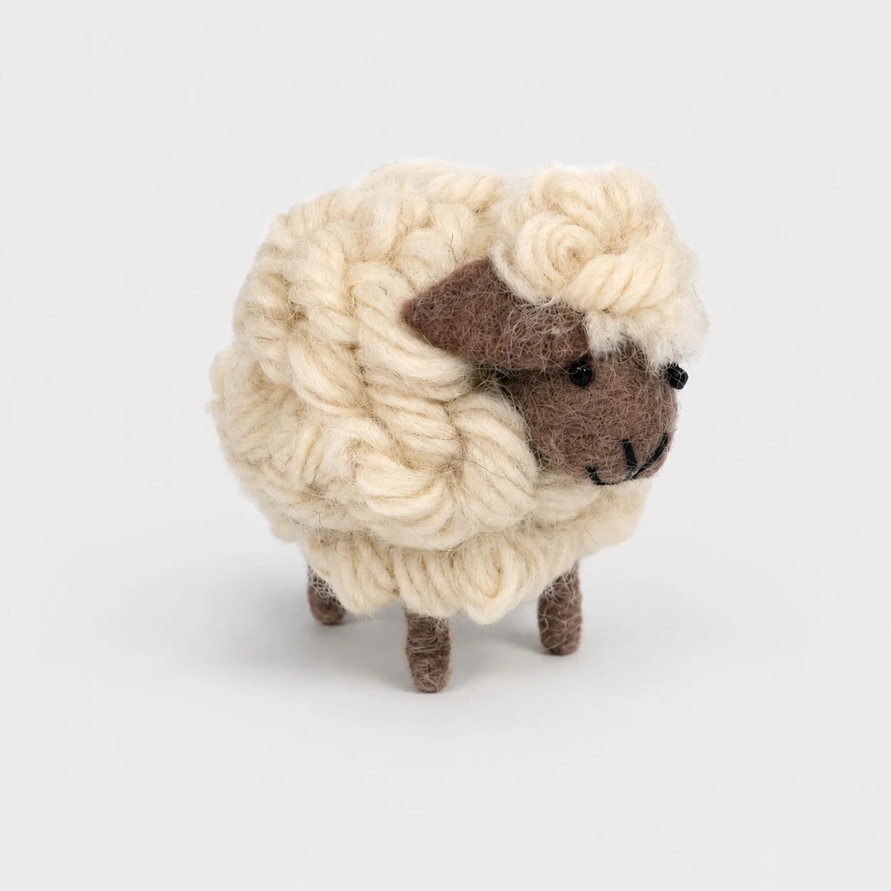 Een handgemaakt schaapje van wolvilt, 8 x 6 cm.