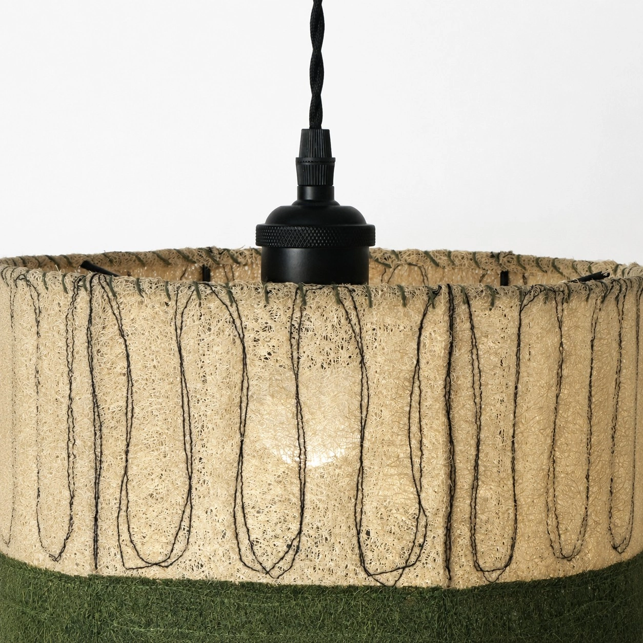 Detailweergave van een matzwart stopcontact en een loofah-lampenkap.