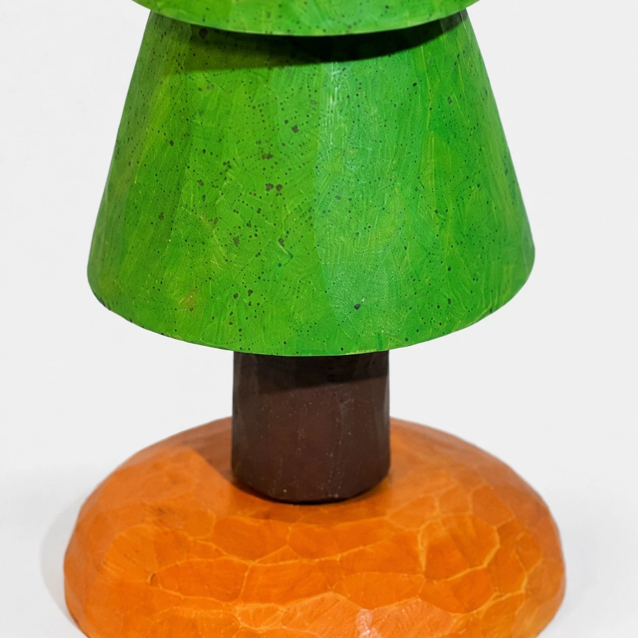 Dettaglio di un livello verde intagliato e di un tronco di legno.